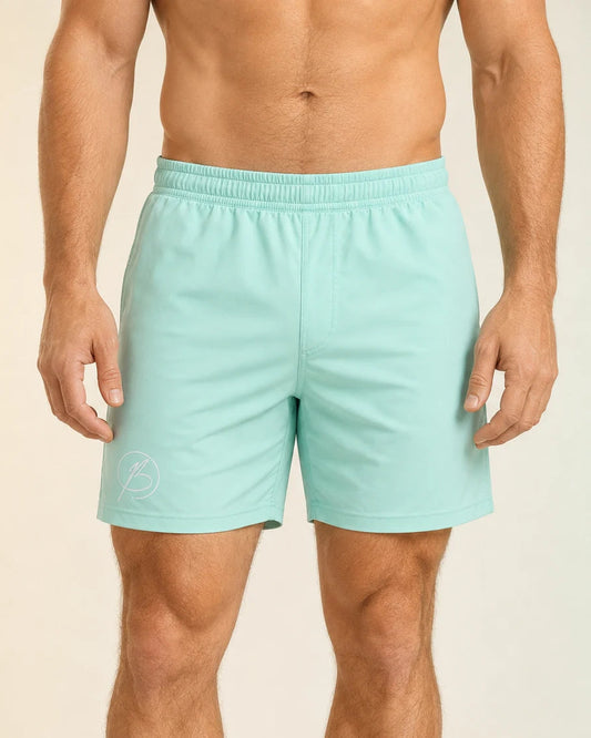 A man wearing light mint green athletic shorts, shown from the waist down against a plain beige studio background.