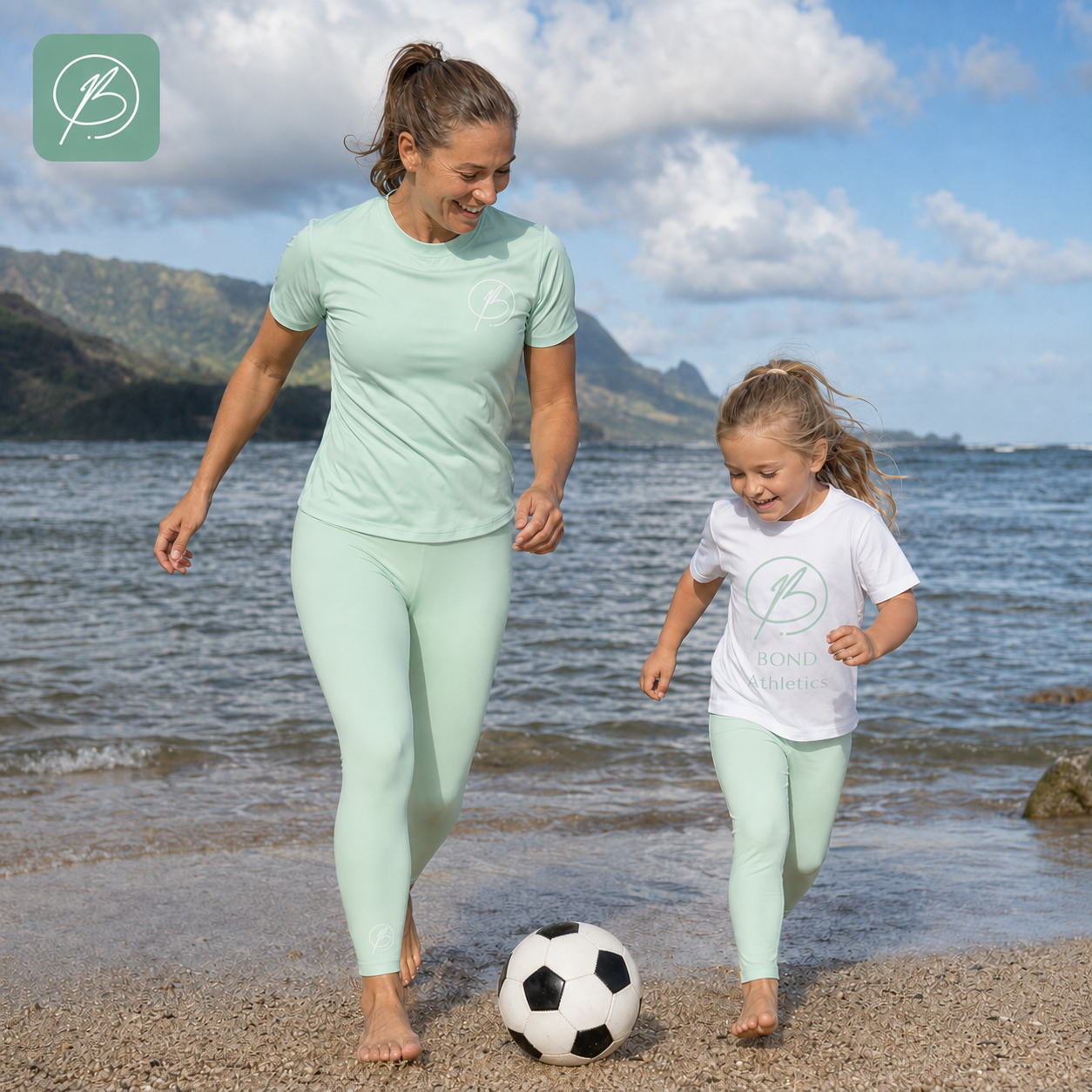 A woman and a child walking barefoot on a beach shoreline, wearing matching mint green athletic sets from Bonio Frames. The woman wears a light mint green short-sleeve top and leggings, and the child wears a white short-sleeve top with a light mint green leggings.