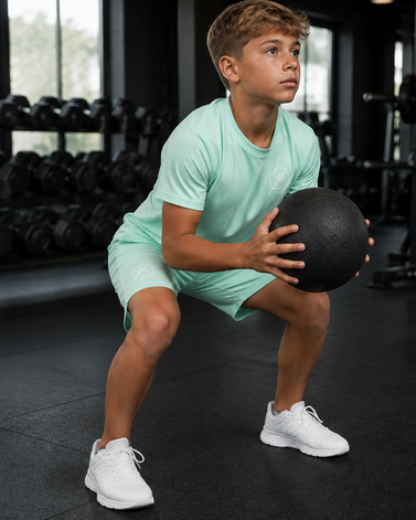 A composite product information graphic for a mint green athletic shorts set, showing front and side views on models, close-up detail shots of the shorts, and an in-gym action scene. Text labels identify key features such as lightweight fabric, breathable mesh, elastic waistband, and non-binding pockets.