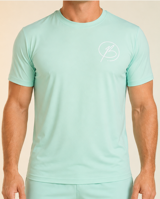 A man wearing a mint green athletic short-sleeve shirt and matching shorts with a small white circular logo on the chest, photographed against a plain light beige studio background.